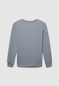 T-shirt gris à manches longues en tissu doux. Il présente un col rond et des poignets côtelés. Design simple sans motifs supplémentaires.