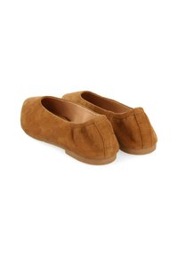 Mocasines de ante marrón con puntera redondeada, detalle de costura minimalista y suela de goma plana. La textura parece suave y lisa.