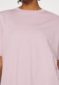Rosa bomull t-shirt med rundad halsringning och korta ärmar. Har en liten, broderad Nike-logotyp i ljusblått på bröstet.