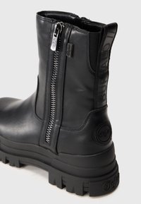 Czarne skórzane botki za kostkę z bocznym zamkiem błyskawicznym, elastycznym panelem oraz gumową podeszwą z teksturowanym wzorem i detalem logo.