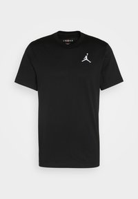 T-shirt en coton noir à manches courtes, col rond et logo Jumpman brodé en blanc sur la poitrine gauche. Texture douce, coupe standard.