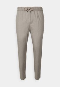 Pantalones de corte slim en beige con cintura elástica y cierre de cordón, fabricados en tejido ligero y tejido.