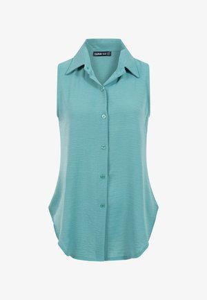 Blouse sans manches bleu clair avec boutons, col pointu, tissu texturé et coupe ample.