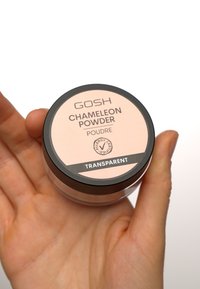 Poudre Chameleon GOSH dans un conteneur en plastique transparent avec un couvercle rond noir. L'étiquette présente un fond rose, du texte noir et la mention "Transparent".