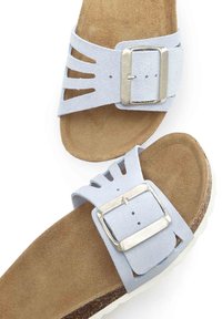 Light blue suede sandals with cut-out design, silver buckle hardware, and tan cork footbed. White sole provides contrast.