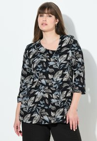T-shirt noir avec un motif floral en blanc et gris. Présente un décolleté en forme d'escargot et des manches trois-quarts, fabriqué en tissu doux.