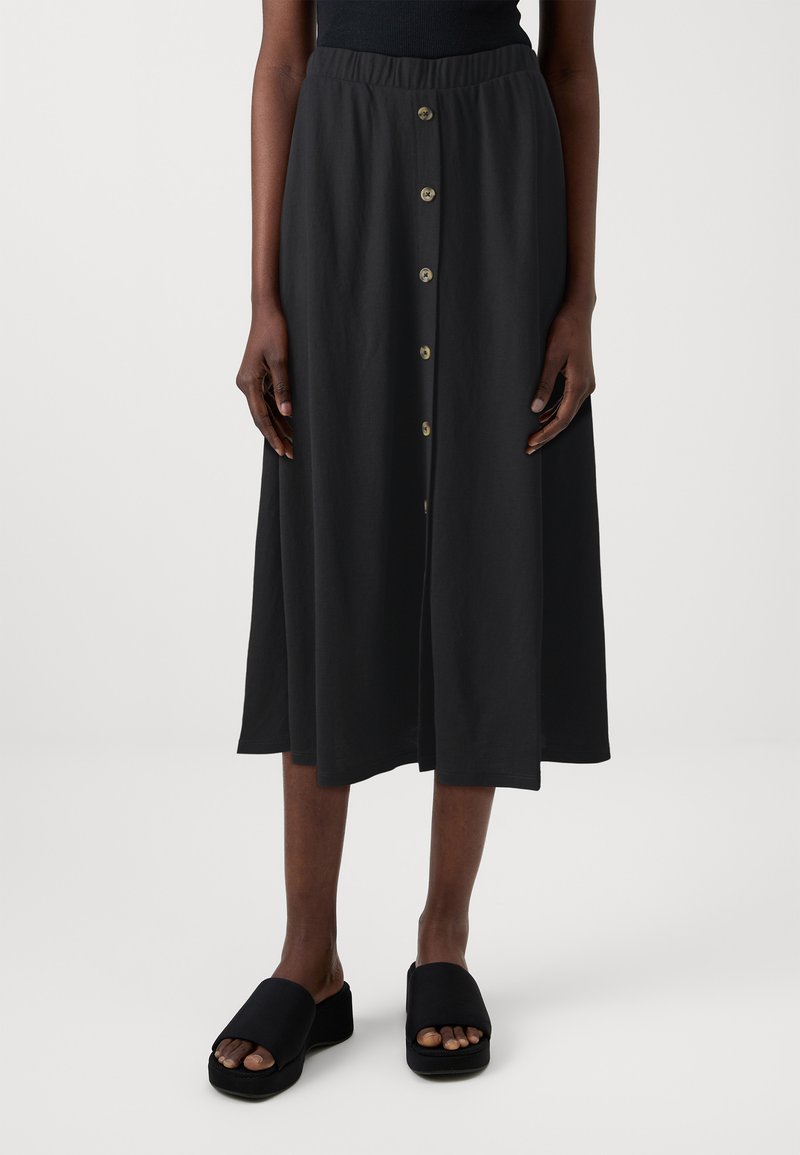 Black midi skirt with a stretchy waistband, front button closure, and smooth texture. Paired with black platform sandals.