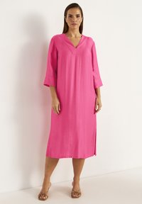 Rosa, knielanges Kleid mit V-Ausschnitt, dreiviertelärmel, seitlichen Schlitzen und glatter Textur. Schlichtes Design ohne Muster oder Verzierungen.