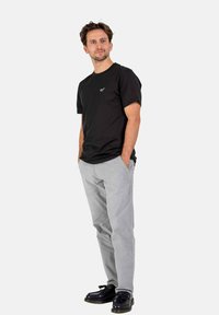 Black short-sleeve t-shirt with a logo, gray pants, and black shoes. The t-shirt is made of cotton, lightweight, with a round neckline.