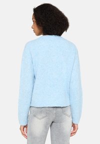 Himmelblauer Pullover aus weichem, strukturiertem Material. Verfügt über einen Rundhalsausschnitt und einen leicht verkürzten Saum sowie lange, körpernahe Ärmel.
