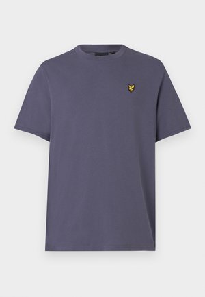 Lila pamut póló, kerek nyakkivágással és rövid ujjakkal, bal mellrészen egy kis sárga madár logóval. Egyszerű dizájn.