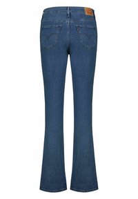 Męskie dzwony z ciemnoniebieskiego denimu. Charakteryzują się wyraźnymi tylnymi kieszeniami o zakrzywionym kształcie oraz skórzaną metką marki na pasku talii.