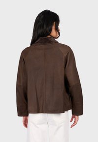 Hnědá kožená bunda s vyvýšeným límcem, hladkou texturou, raglánovými rukávy, bočními kapsami a čistým, minimalistickým designem.