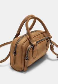 Sac à main en daim tan avec doubles zips, anses courtes et une bandoulière amovible. Doté d'une forme rectangulaire compacte et d'accents en cuir.