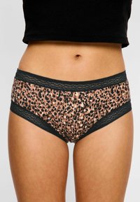 Culottes taille haute imprimées léopard avec des bordures en dentelle noire au niveau de la taille et des jambes ; fabriquées à partir d'un tissu doux et extensible pour plus de confort.