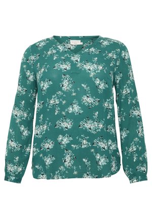 Blusa a maniche lunghe in tessuto teal, con stampa floreale in tonalità di crema e verde, dotata di scollo a V e dettagli di pieghe sottili.