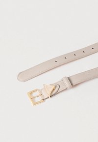 Ζώνη μπεζ με υφή και χρυσή μεταλλική αγκράφα, με τριγωνικό λογότυπο ως διακοσμητικό στοιχείο. Το λουρί διαθέτει πολλαπλές τρύπες ρύθμισης για το μέγεθος.