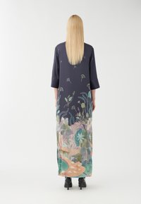 Abito lungo navy con motivi floreali in colori pastello, caratterizzato da una vestibilità ampia, maniche a 3/4 e una silhouette che si estende fino alle caviglie.