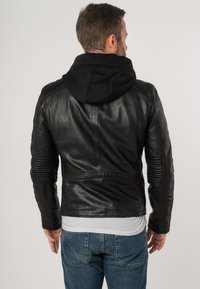 Zwarte leren jas met een afneembare zwarte capuchon, strak ontwerp, geribbelde accenten op de mouwen en een getailleerde silhoeët.