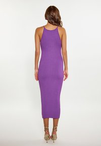 Rochie midi cu dungi în nuanță de mov, având o siluetă ajustată și bretele subțiri. Prezintă o textură fină și un design care se conturează pe corp.