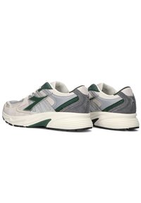 Sneakers atletici caratterizzati da un mix di suede grigio e bianco e mesh, con dettagli verdi. Punta arrotondata e suola spessa bianca.