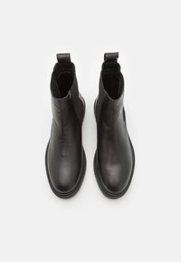 Svarta läderankelboots med en slät finish, elastiska sidopaneler och öglor bak för att dra på. Platta sulor med ett subtilt mönster.