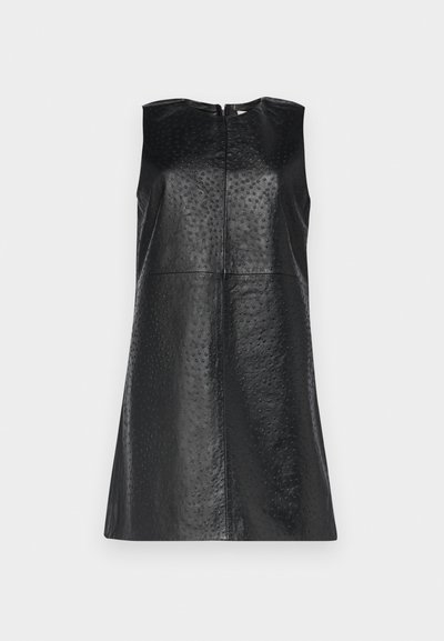 Μαύρο μίνι φόρεμα χωρίς μανίκια, κατασκευασμένο από υφασμάτινο δέρμα, με μπροστινό φερμουάρ και ευθεία σιλουέτα που διαθέτει διακριτικά μοτίβα με κουκίδες.