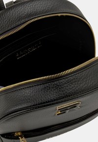 Zaino in pelle nera con finitura texturizzata, cerniera dorata e tasca interna. La fodera è nera, con dettagli in metallo dorato.