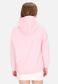 Sudadera con capucha rosa de textura suave y puños acanalados, con un corte relajado y un cordón en la capucha.