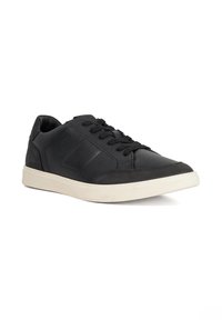 Black leather sneaker with textured panels, round toe, and flat white rubber sole. Features black laces and a padded collar for comfort.