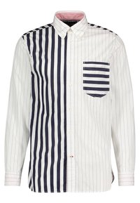 Camicia a bottoni a righe con strisce verticali bianche e blu navy. Presenta una tasca applicata con strisce orizzontali blu navy e un colletto a contrasto.