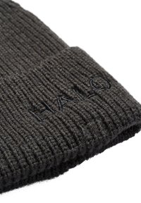 Ciemnoszara dzianinowa czapka z prążkowaną fakturą, z wyszywanym logo "HALO" na złożonym mankiecie. Miękki wełniany materiał.