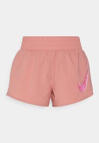 Pantalones cortos deportivos rosas con una cintura elástica. Presenta un logo estilizado de Nike en rayas rosas y blancas en el muslo izquierdo.
