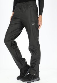 Zwarte waterdichte broeken met een elastische tailleband, tapered fit, zijzakken en een klein logo op de dij. Ontworpen voor gebruik buitenshuis.