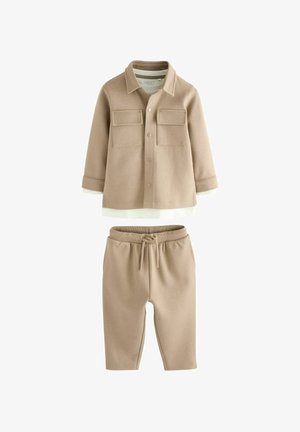Beiges Zweiteiler-Outfit mit einer Knopfleiste, zwei Brusttaschen und passenden elastischen Taillenhosen. Weicher, strukturierter Stoff.