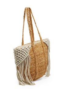 Borsa tote in paglia intrecciata con manici intrecciati, caratterizzata da accenti in macramè bianchi e frange decorative sui lati. Forma rotonda, colore beige.