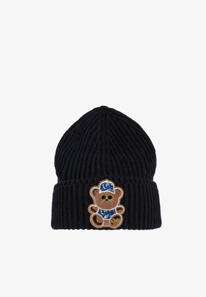 Gebreide marineblauwe muts met ribbelstructuur en opvouwbare rand, voorzien van een tan teddybeer patch in een blauwe pet aan de voorkant.