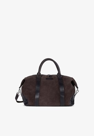 Brun semsket duffelbag med svarte skinnakenter og stropper. Har doble håndtak og justerbar skulderrem, låsestengsel og logo detalj.