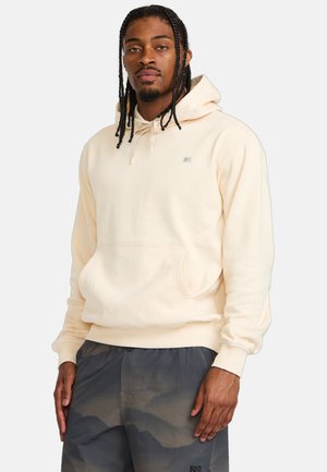 Cream-colored hoodie with a front pocket, adjustable drawstring hood, and embroidered logo detail on the chest. Cotton-blend fabric, soft texture.