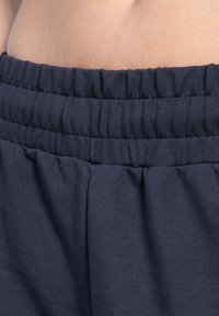 Marineblauwe elastische tailleband met geplooide textuur; zachte stof; comfortabele pasvorm; minimale stiksel details aan de naad voor extra comfort.