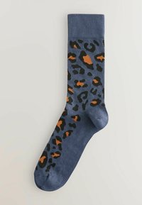 Zili zeķes ar leopardu rakstu melnā un oranžā krāsā. Materiāls ir mīksts ar gludu tekstūru un ribotu aproci.