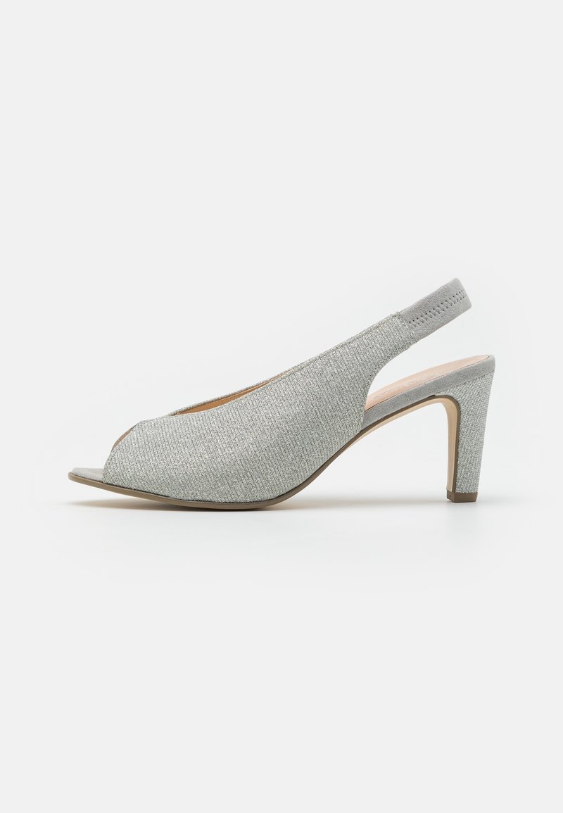 Chaussure à talon haut à bride arrière pailletée argent avec bout ouvert et talon fin sur fond blanc.