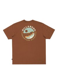 Hnědé bavlněné tričko s kulatým grafickým designem na zádech, na kterém jsou vlny, hory a slunce, doplněné nápisem "BILLA BONG ADVENTURE DIVISION."
