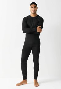 Top termico nero a maniche lunghe e leggings, realizzati in materiale liscio ed elasticizzato, design aderente con maniche lunghe e polsini alle caviglie.