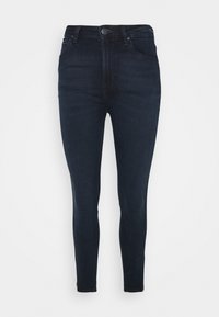 Jeans skinny de mezclilla de color azul oscuro, con un clásico cierre de botón y cremallera, cinco bolsillos y un sutil detalle de costura a lo largo de las costuras.
