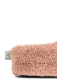 Rosa pälskudde med en mjuk och fluffig textur. Har en platt design och en liten tygetikett på ena sidan.