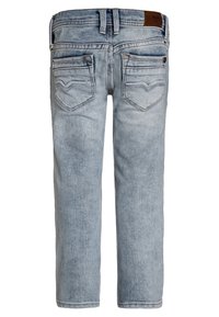 Vaqueros de mezclilla azul claro con un diseño de pierna recta, bolsillos traseros y un parche de cuero marrón en la cinturilla. Detalles de acabado desgastado.