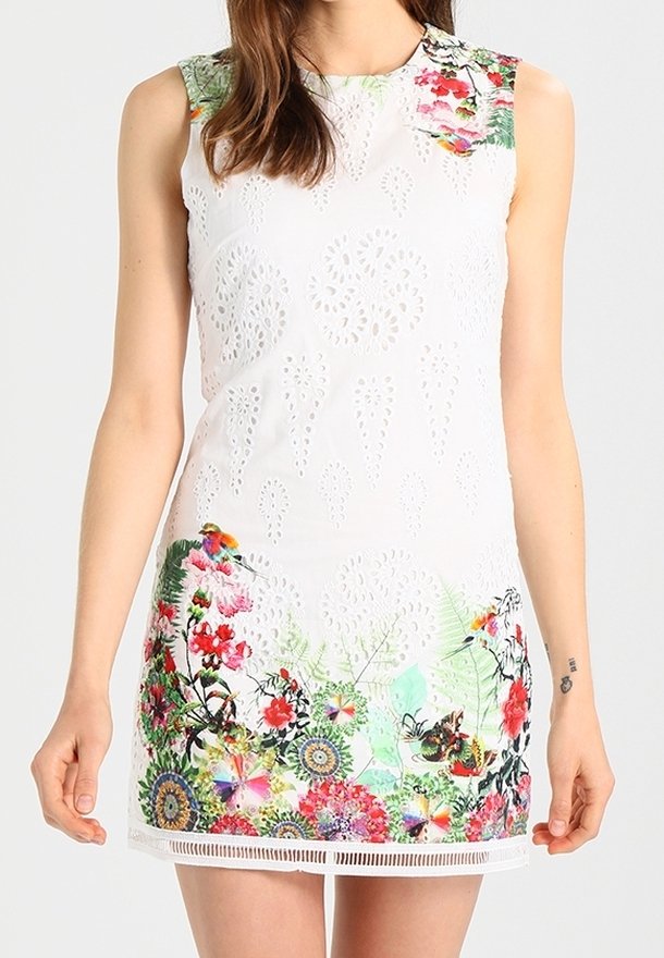 Robe blanche sans manches avec des motifs œillets et des imprimés floraux et papillons colorés le long de l'ourlet et des épaules.