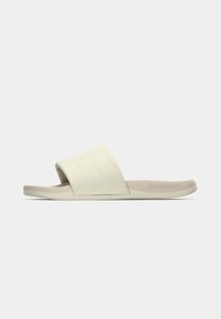 Λευκό σανδάλι με φάσα με υφή που διαθέτει οριζόντιες ραβδώσεις. Η σόλα είναι ελαφρώς πιο χοντρή, σχεδιασμένη για άνεση, με την ένδειξη «CLOUDFOAM».