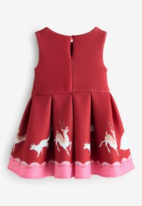 Czerwona sukienka bez rękawów z plisowanym dołem, zdobiona wzorami białych jeleni i lisów. Okrągły dekolt, zapięcie na guziki z tyłu, różowy brzeg.